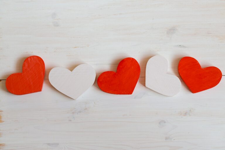 Red and white hearts on white wooden background