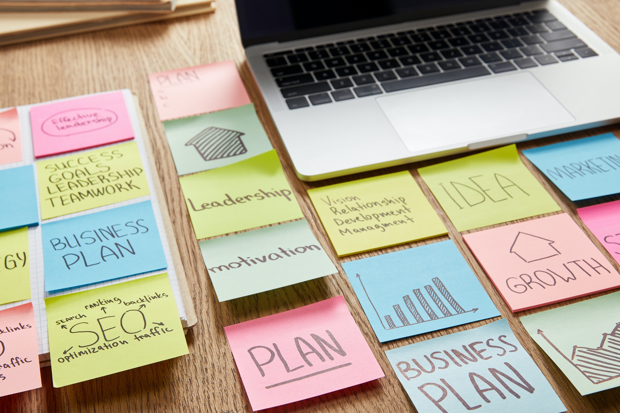 colored paper stickers with business strategy and laptop on tabletop